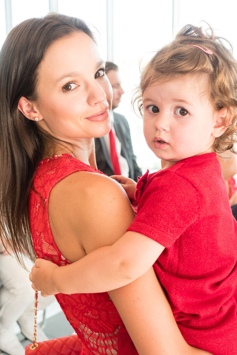 Frau mit KLeinkind auf dem Arm in rot gekleidet